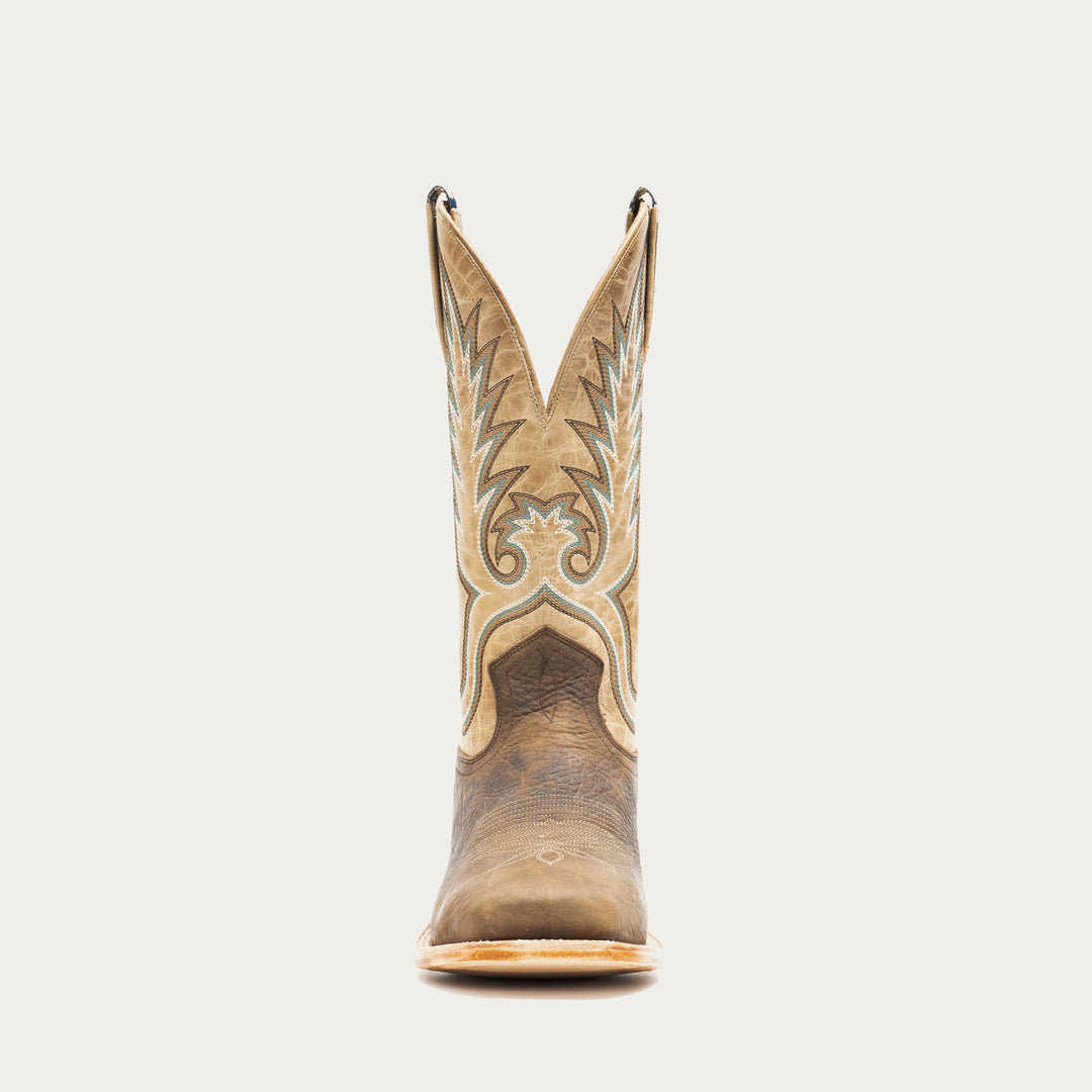 Brown and tan cowboy boot with intricate design on a light gray background
