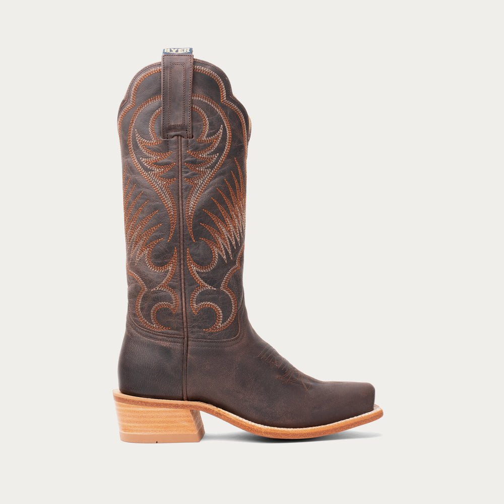 Side profile of Brown cowboy boot with intricate design on a light gray background