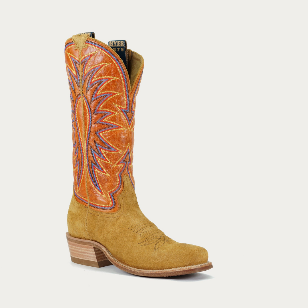 A tan leather cowboy boot with a geometric stitching pattern in orange and purple on the orange upper shaft.